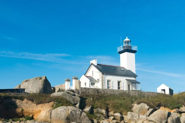 Un phare avec une extension blanc et en pierre isolé en Bretagne