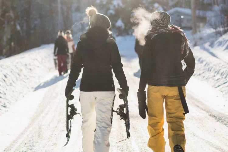 Personnes avec leurs skis se rendant sur les pistes