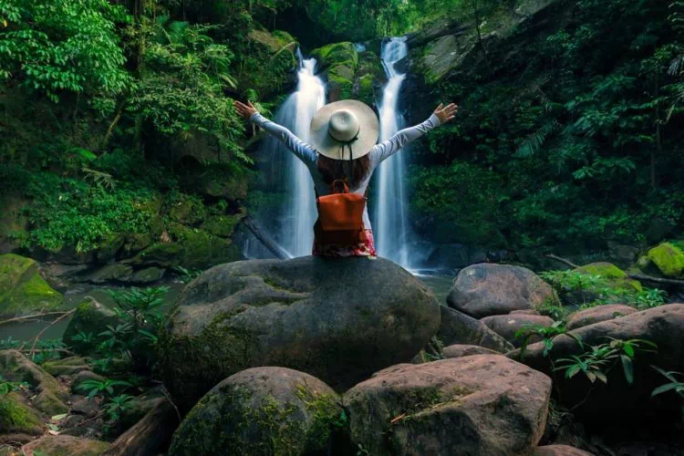 Femme devant une cascade